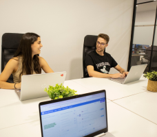 Equipo joven trabajando con portátiles en un despacho acristalado de Cink Coworking